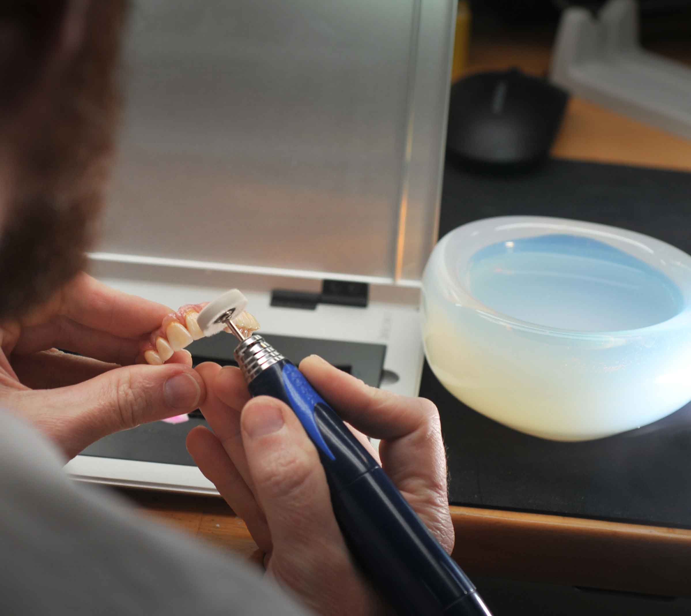Prothésiste en train de finir une prothèse au laboratoire